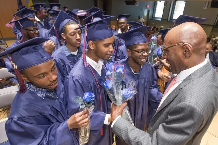 Boys Latin of Philadelphia’s founder David Hardy is presented blue roses by members of Class of 2017 during graduation ceremony on June 13, 2017. Ten years after Boys Latin of Philadelphia opened at least 84 percent of Boys Latin’s grads go to college and earn degrees.