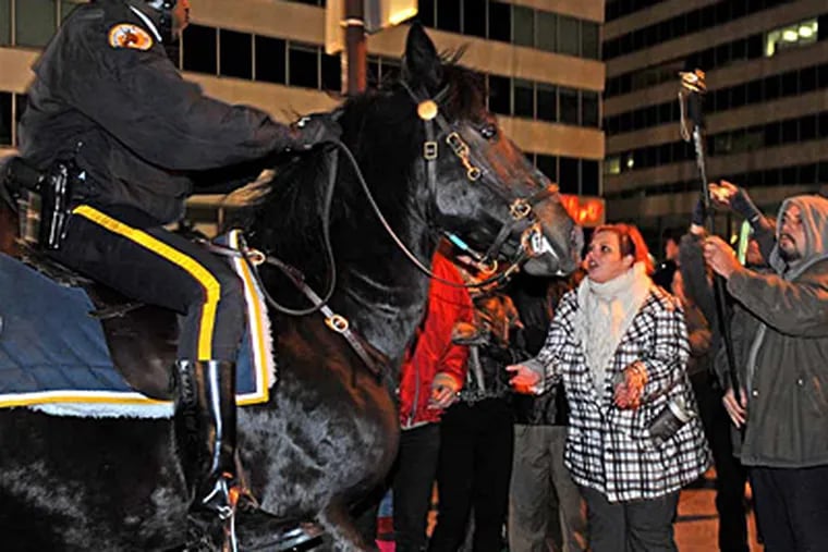 Occupy Philadelphia gets evicted. Here, demonstrator Lauren Foley of Philadelphia is confronted by a police on horseback.  "That was so scary," she said later. ( APRIL SAUL / Staff Photographer)