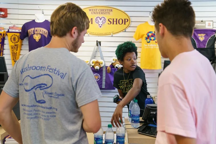 Katie Noll, center, works the cash register at The Ram Shop, a new convenience store on West Chester University's campus, which is staffed in part by students who have autism, in West Chester, PA, Thursday, Aug. 29, 2019.