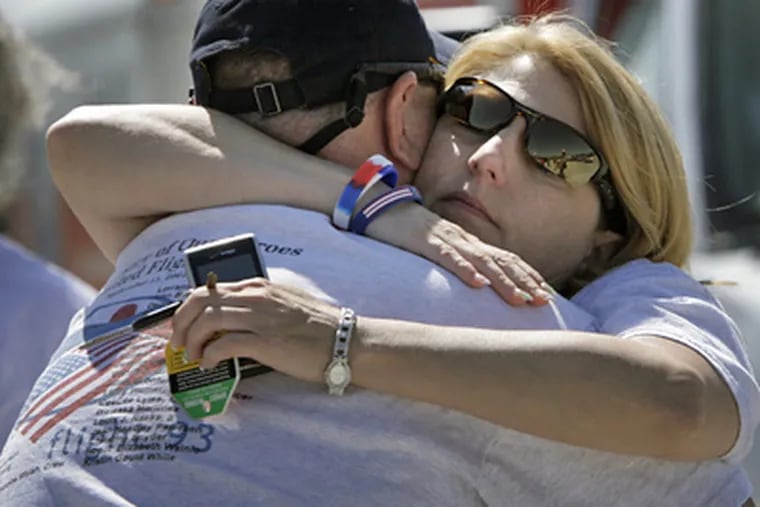 Ken Nacke, whose brother Louis Nacke was a passenger aboard Flight 93, is embraced by his wife, Marci Nacke, at the temporary memorial in Shanksville, Pa on Thursday. (Laurence Kesterson / Staff Photographer)