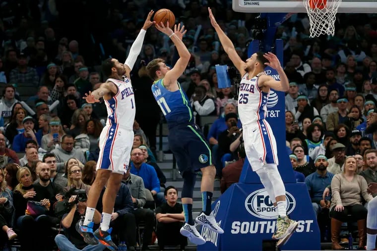 76ers forward Mike Scott (1) blocks a shot by Dallas Mavericks forward Luka Doncic (77) as 76ers guard Ben Simmons (25) defends during the first half.