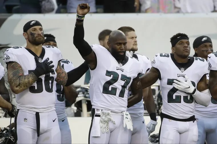 Philadelphia Eagles’ Chris Long, from left, Malcolm Jenkins and Rodney McLeod stand on the sidelines during the playing of the National Anthem before a preseason NFL football game against the Miami Dolphins.