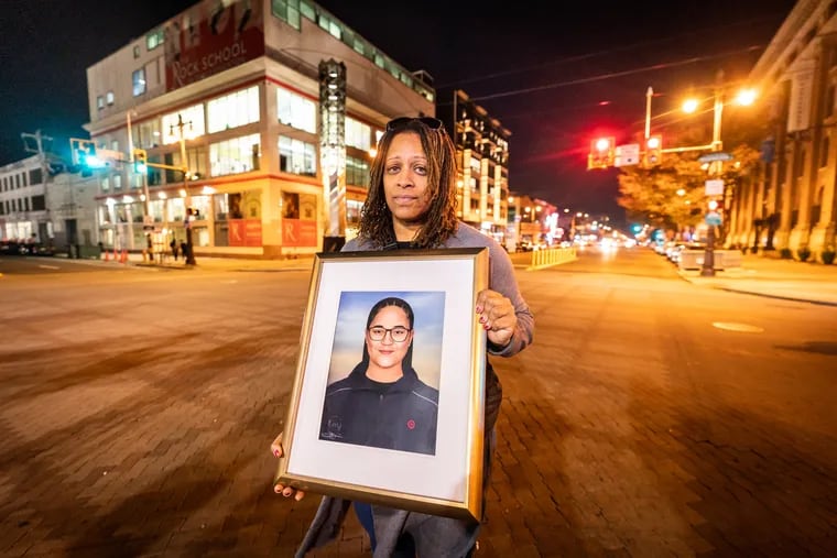 Roseann Morrison holds a painting of her daughter Sahmya Garcia after a candlelight vigil at Broad Street and Washington Avenue.