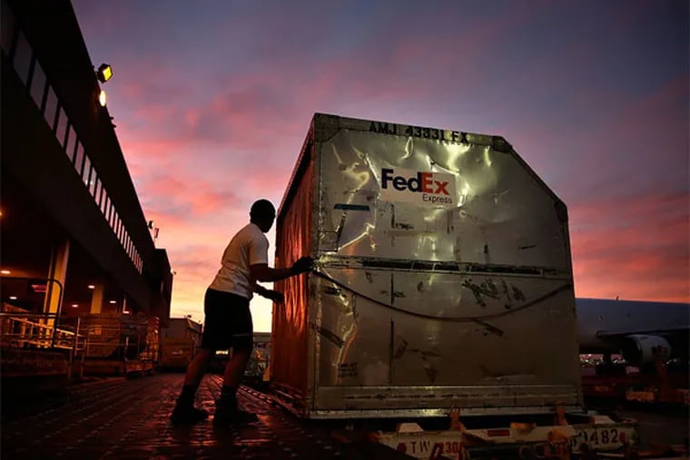 FILE - In this Monday, Dec. 2, 2013, file photo, Moulton Tuuoloaki prepares to load a container onto a FedEx cargo plane at the FedEx hub at Los Angeles International Airport in Los Angeles. Dozens of online subscription businesses in recent years have popped up that offer to ship boxes of goodies within a given niche or theme, like makeup or shoes, each month for $1 to about $50. Most often, the exact products remain a mystery until they’re shipped (AP Photo/Jae C. Hong)