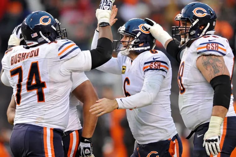 Bears quarterback Jay Cutler, center, is congratulated by his linemen after running back Michael Bush ran 40 yards for a touchdown against the Cleveland Browns in the fourth quarter of an NFL football game Sunday, Dec. 15, 2013, in Cleveland. (David Richard/AP)