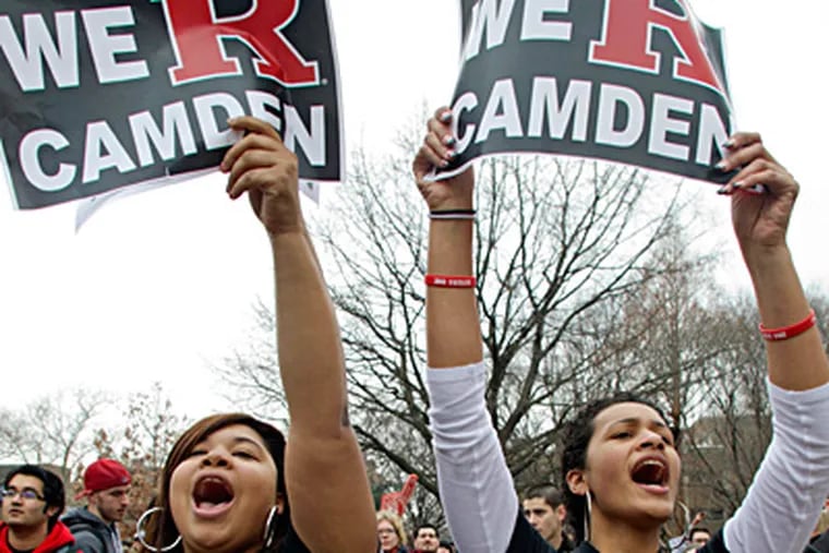 File: Myasai Johnson (left), a freshman from Mount Laurel, and Stefanie Perez, a freshman from Island Park, N.J., hold signs during a student protest at Rutgers-Camden of a proposed merger with Rowan University.