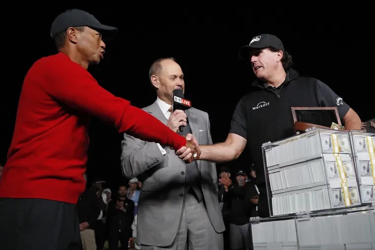 Tiger Woods (left) shakes hands after losing a golf match to Phil Mickelson, right, at Las Vegas' Shadow Creek golf course, on Friday.