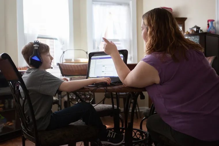 Caleb McGough, 10, does schoolwork with his mother, Rebecca Penglase, at her dining room table Saturday, March 16, 2019. McGough is one of more than 34,000 Pennsylvania students who attend cyber charter schools, and he started school online after moving to Northeast Philadelphia because his mother feared he would be bullied as he was in his New Jersey elementary school.