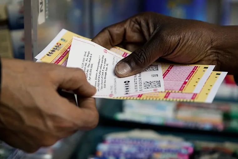 A person purchases Powerball lottery tickets from a newsstand in Philadelphia.