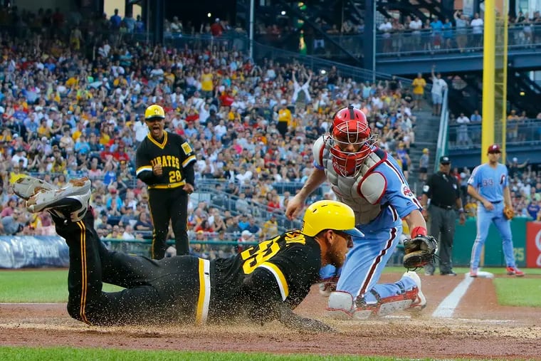 Joe Musgrove #59 of the Pittsburgh Pirates scores on a RBI single in the third inning against J.T. Realmuto #10 of the Philadelphia Phillies at PNC Park on July 20, 2019 in Pittsburgh, Pa. The Pirates won, 5-1. (Justin K. Aller/Getty Images/TNS)
