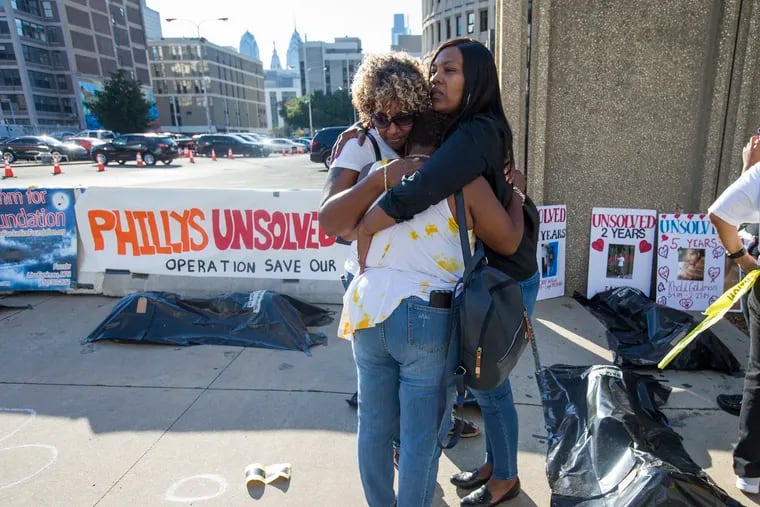 L-R: Shona McCellan, Sonya Dixon, and Danielle Shaw-Ogelsby pray together at the 2nd day of silent protests held by the families of unsolved murder victims by Police Headquarters on Sept. 25, 2019. All 3 women had children or grandchildren murdered. Dominique Ogelsby and Erica McCellan are solved but Dixon’s two grandsons, separate events in 2017, remain unsolved.