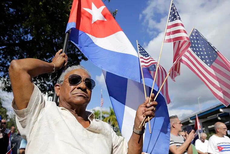 Evilio Ordonez holds Cuban and American flags during a protest in Miami’s Little Havana neighborhood against President Obama’s plan to normalize relations with Cuba. (Associated Press)