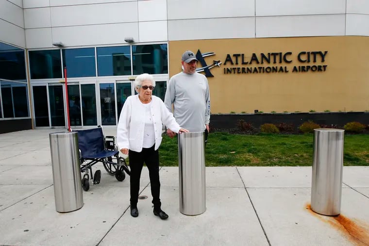 Betty Scottino, 92, leaves the Atlantic City International Airport with her grandson Ed Bober of Hammonton on Sunday after arriving on a near-empty flight from Florida, seemingly unfazed by the coronavirus pandemic and a related travel advisory.