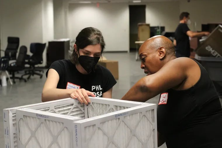 Hannah Holiday and Tonya Bah construct a Corsi-Rosenthal box, a DIY air purifier, for use in Philadelphia public schools, in this 2021 file photo. Holiday and Bah are part of a group of parents and community members who want better air quality in Philadelphia School District schools.
