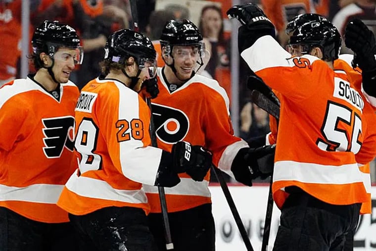 Philadelphia Flyers' Michael Raffl (12), center, celebrates his empty-net goal with teammates in the closing minute of the third period of an NHL hockey game against the Detroit Red Wings, Saturday, Oct. 25, 2014, in Philadelphia. The Flyers won 4-2. (AP Photo/Tom Mihalek)