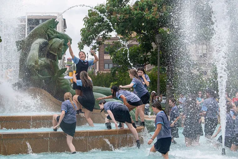 Students from John W. Hallahan Catholic Girls High School follow tradition by jumping in the Swann Memorial Fountain on the last day of school in Philadelphia earlier this month.