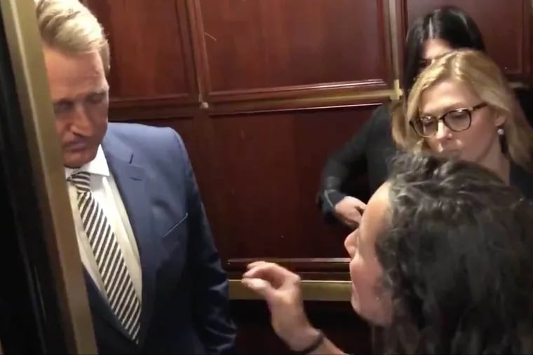 Protester Ana Maria Archila, right, as she and Maria Gallagher (not in picture) confront U.S. Senator Jeff Flake of Arizona on an elevator that would take him to the Senate Judiciary Committee meeting on Capitol Hill last Friday.