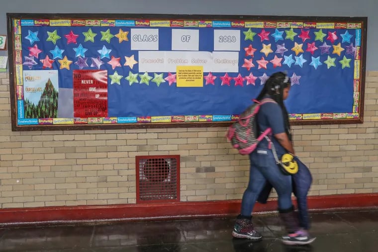 A Mitchell Elementary student walks by a bulletin board that promotes the number of days eighth-grade students have gone without getting into fights. Students will earn $100 each at graduation if they do not resort to physical violence.