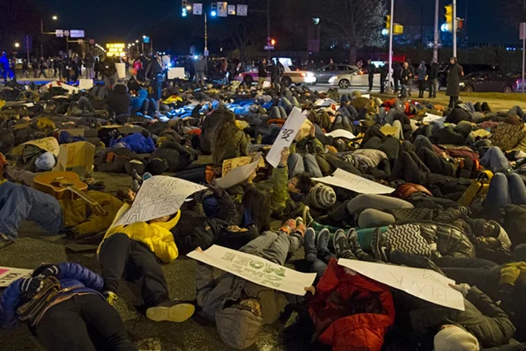 Hundreds of people heeded the call of Philadelphia clergy of all faiths for a Solidarity Die-In at the intersection of S. Broad St. and Pattison Ave. after the end of the Eagles games Dec. 7, 2014.  The protestors laid in the street for 4 1/2 minutes, symbolically mirroring the 4 1/2 hours Michael Brown's body laid in the street in Ferguson, Mo. (CLEM MURRAY/Staff Photographer)
