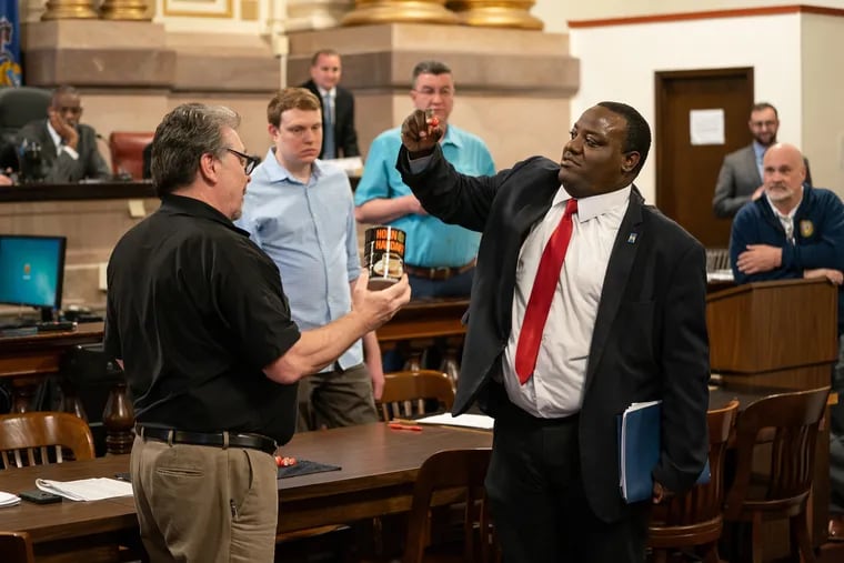 Devon Cade (right) draws for ballot position out of a coffee can held by Kevin Kelly, acting supervisor of slections, in City Hall on Wednesday.