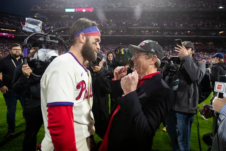 Bryce Harper (left) and managing partner John Middleton share a moment as the Phillies celebrate their victory over the Padres in Game 5 of the National League Championship Series.