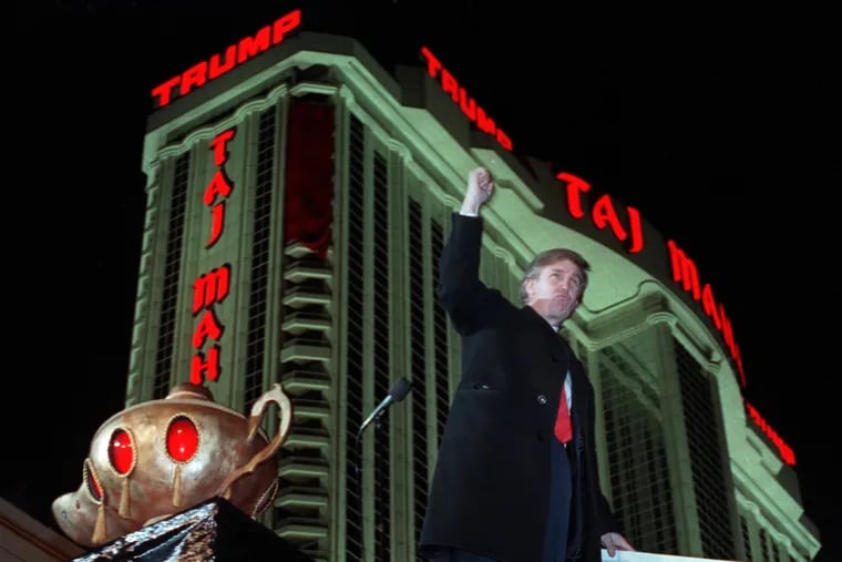 In this April 5, 1990, file photo, Donald Trump ascends the stairs with his fist raised from the genie's lamp after opening the Trump Taj Mahal Casino Resort in a spectacular show of fireworks and laser lights in Atlantic City, N.J.