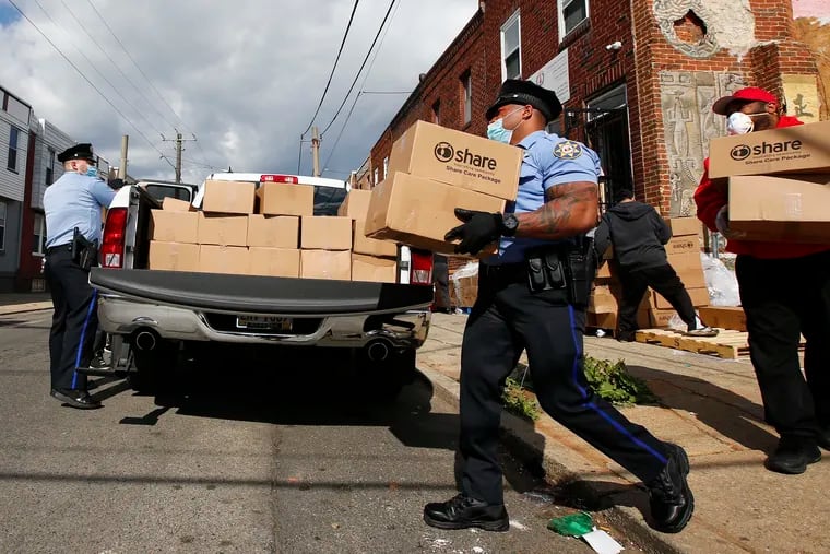 Philadelphia Sheriff Officers and volunteers load boxes of food, bound for North Philadelphia residents, from the Share Food Program distributed at the Young Chances Foundation in Point Breeze in April.