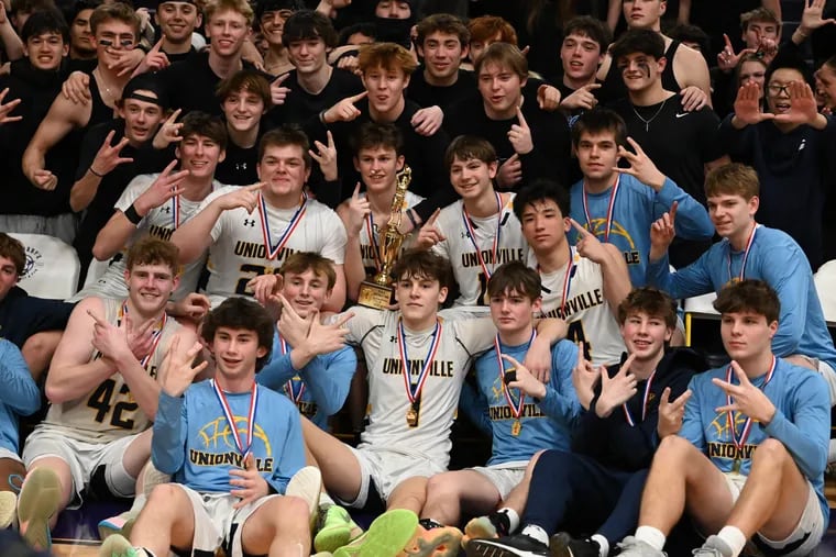 The Unionville boys basketball team celebrates with its student section following Thursday’s District 1 5A championship against Upper Dublin at West Chester.