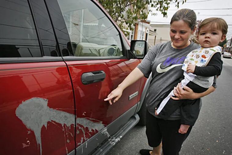 Jaine Kromchad, with son Nicholas, is one of many residents around Second and Wolf that had their cars vandalized overnight. (Alejandro A. Alvarez / Staff Photographer)