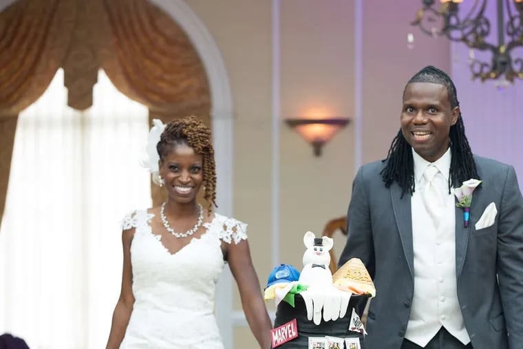 Newlyweds Zupenda Davis and Randy Shine, with the groom's cake, showcasing his love of magic, his alma mater Penn State, his fraternity, WWE Wresting, and comic books.