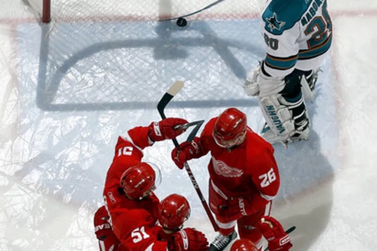 San Jose Sharks goalie Evgeni Nabokov clears the puck from the net after one of six Detroit goals.