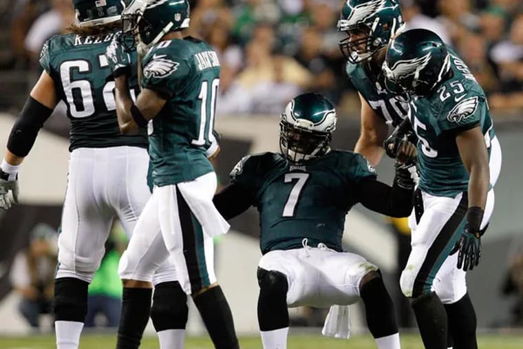Michael Vick gets help from his teammates after a fumble during the first quarter. (David Maialetti/Staff Photographer)