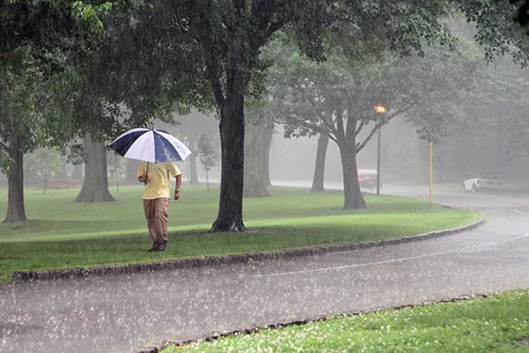 A man walks through the rain in Franklin Delano Roosevelt Park, in Philadelphia, on Tuesday, June 18, 2013.  ( Stephanie Aaronson / Staff Photographer )