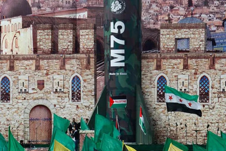 Hamas activists wave Islamic flags in front of a stage decorated with a mural of Jerusalem and a model of a rocket at a rally Saturday.