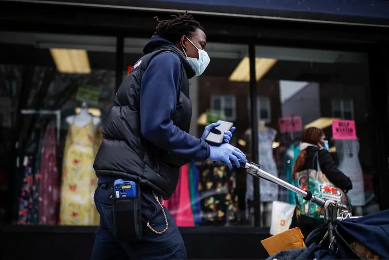 A postal worker wears a protective mask and gloves while operating a route in the Queens borough of New York in March 2020. Health experts say the risks are very low that coronavirus will remain on envelopes or packages and infect anyone that comes in contact with it. But those on the frontlines of all those deliveries are taking steps to try to protect themselves.