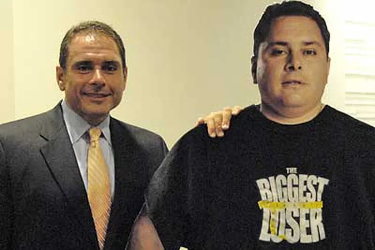 Bill Germanakos stands with a poster of him when he began the television show The Biggest Loser. (Jonathan Wilson/Staff Photographer)