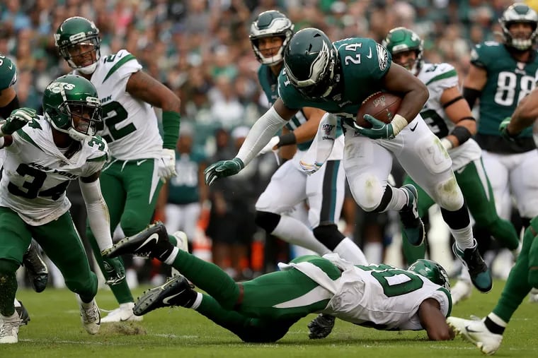 Eagles running back Jordan Howard, top, is tackled by Jets free safety Marcus Maye, bottom, during the third quarter.