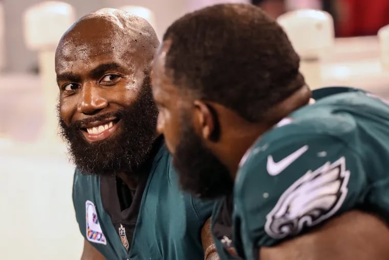 Eagle safety Malcolm Jenkins, left, smiles while talking to teammate Fletcher Cox, on the sideline late in the game against the Giants.