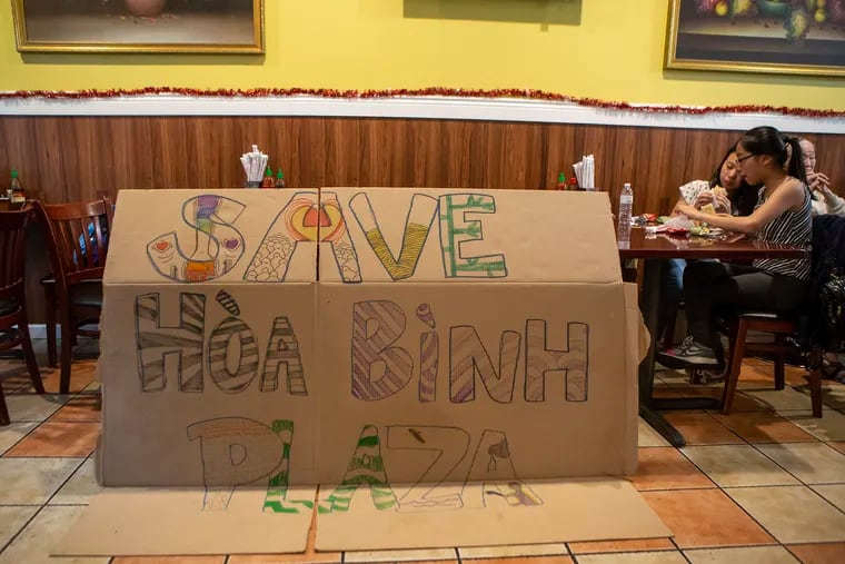A sign to save Hoa Binh Plaza sits in Huong Tram restaurant at the end of a rally in support of saving the plaza on Tuesday evening, June 25, 2019. The plaza is reportedly being bought by a developer, to be replaced with 44 residential units.