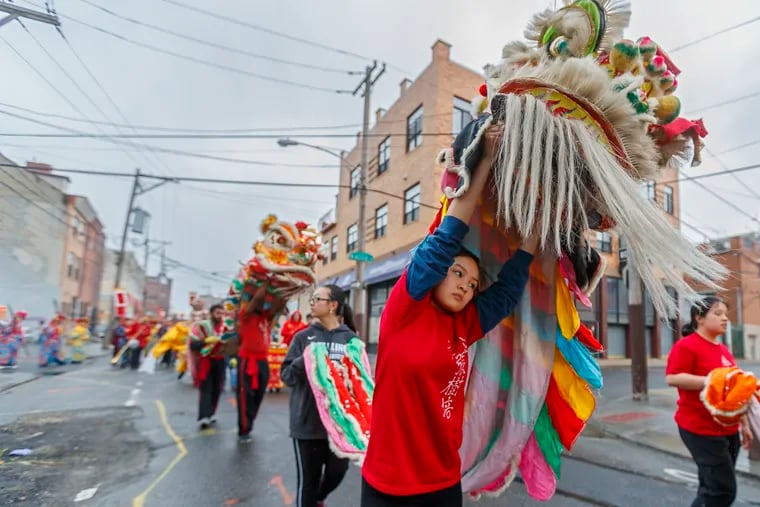 Lion dancers lead the 2019 Chinese Hoyu Folk Culture Parade down 10th 
Street toward the center of Chinatown on Sunday.