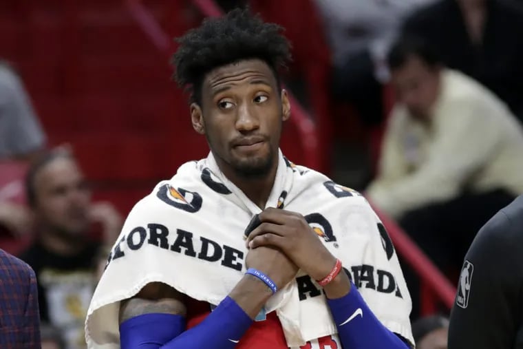 Robert Covington watches from the bench during the fourth quarter of the Sixers game against the Heat.