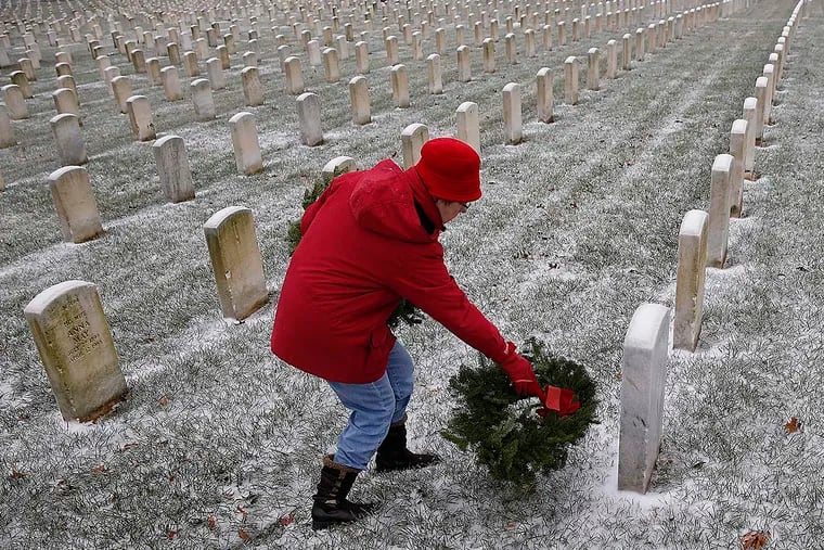 Jane Bostock, of Bryn Athyn, PA, lays a wreath as part of the Wreaths Across America program at Philadelphia National Cemetery on December 17, 2016 in Philadelphia, PA. Her father served in WWII.