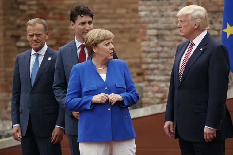 German Chancellor Angela Merkel talks with President Trump during a photo session with G7 leaders in Italy.