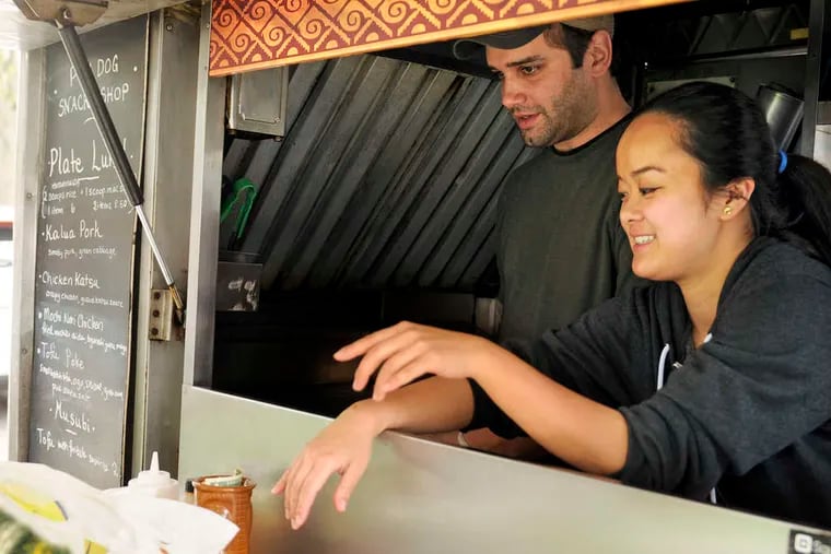 At Poi Dog, on Temple's campus, owners Chris Vacca and Kiki Aranita greet customers from their Hawaiian food truck. They have three advanced degrees in classic literature between them. TOM GRALISH / Staff Photographer