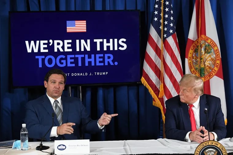 Then-President Donald Trump (right) and Florida Gov. Ron DeSantis hold a COVID-19 and storm preparedness roundtable in Belleair, Fla., on July 31, 2020.