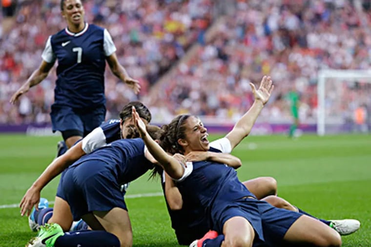 Delran’s Carli Lloyd (right) celebrates with teammates after scoring the first of two goals at Wembley Stadium. (AP)
