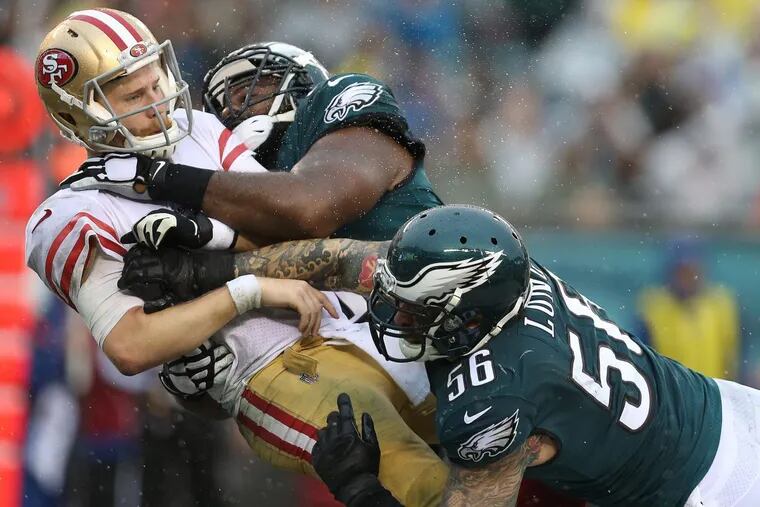 49ers’ quarterback C.J. Beathard, left, is hit by the Eagles’ Fletcher Cox, center, and Chris Long, right, after releasing the ball in the 3rd quarter. Philadelphia Eagles win 33-10 over the San Francisco 49ers in Philadelphia, PA on October 29, 2017. The pass fell incomplete. DAVID MAIALETTI / Staff Photographer