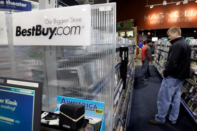 A customer peruses the videos at a Best Buy in Mountain View, Calif. The nation&#0039;s biggest consumer-electronics retailer said yesterday that its third-quarter profit sank 77 percent. Consequently, it plans to offer massive buyout packages to about 4,000 employees at its headquarters, while slashing spending, in a bid to cut costs.