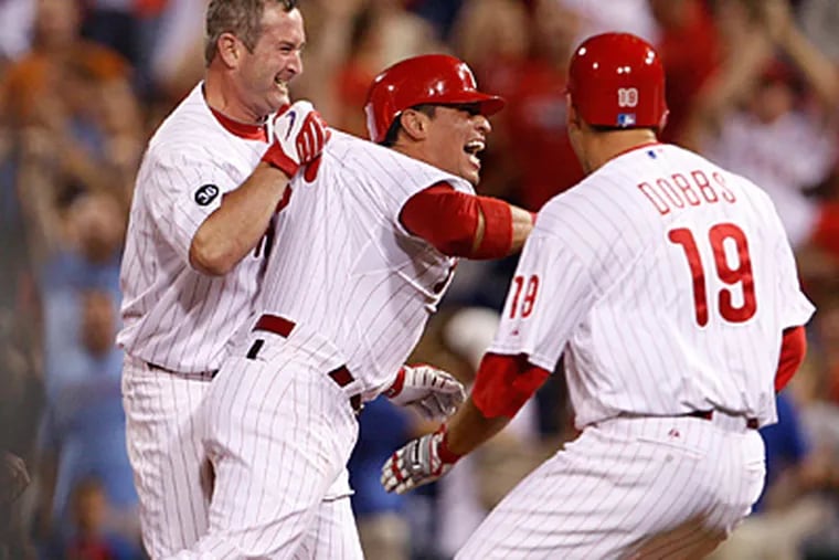 Carlos Ruiz is grabbed by Brian Schneider, left, after Ruiz' game winning hit in the ninth. (Ron Cortes / Staff Photographer)