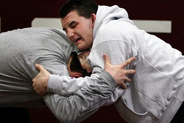 Mauro Correnti, right, a 220-pound wrestler, spars with his coach, Adam
Cooney, at Holy Cross High School. (Laurence Kesterson/Staff Photographer)